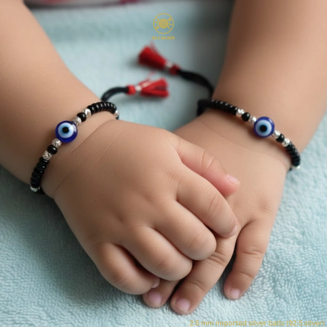 Embrace Divine Protection and Elegance for Your Little One. Keep your baby safe and stylish with our handcrafted Kanhaji Jewels (KJJ) Nazariya bracelets. Specially designed for delicate wrists, these bracelets combine traditional protection with the premium quality of 92.5 Sterling Silver. Each bracelet features imported 2.5mm pure silver balls nestled between classic black beads and vibrant blue evil eye charms. The adjustable black thread ensures a soft, comfortable fit that grows with your child, making it the perfect gift for newborns and toddlers alike. Key Features: Certified Purity: Crafted with genuine 92.5% Sterling Silver components for lasting shine and durability. Imported Silver Beads: Features premium 2.5mm silver balls that add a touch of luxury to the traditional design. Ultimate Protection: The blue evil eye charms are traditionally believed to ward off negativity and keep your little one safe. Gentle on Skin: Made with high-quality, non-irritating materials suitable for sensitive baby skin. Perfect for Gifting: An ideal choice for baby showers, naming ceremonies (Namkaran), or first birthdays. Product Specifications: Brand: Kanhaji Jewels (KJJ) Material: 92.5 Sterling Silver & High-Grade Black Thread Silver Ball Size: 2.5 mm Set Includes: 1 Pair (2 Bracelets)